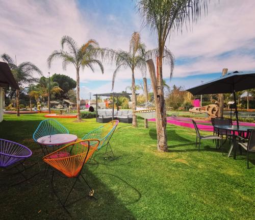 a park with tables and chairs and palm trees at Casa Flores Hotel & Spa in Atlixco