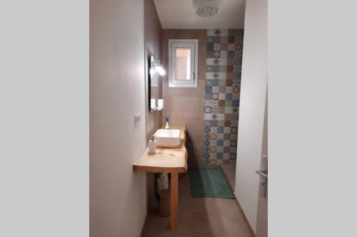 a bathroom with a sink and a mirror at Le liberté in Aubenas
