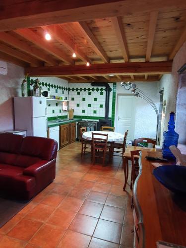 cocina y sala de estar con mesa y sofá en Cottage 2 personnes, en Lormes