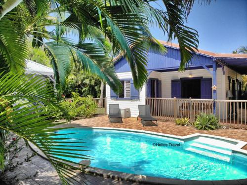 a swimming pool in front of a house at Villa Deshaies in Deshaies