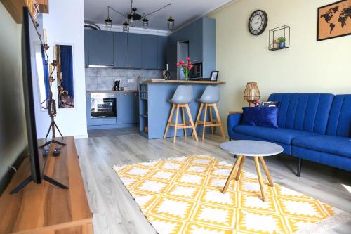 a living room with a blue couch and a table at Dominic Apartment by the Forest in Timişoara