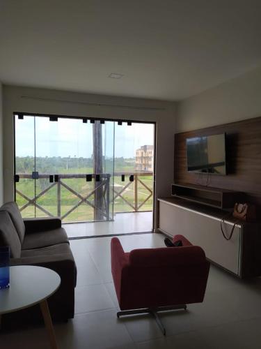 a living room with a couch and a flat screen tv at Apartamento Condomínio Sonhos da Serra - Bananeiras in Bananeiras