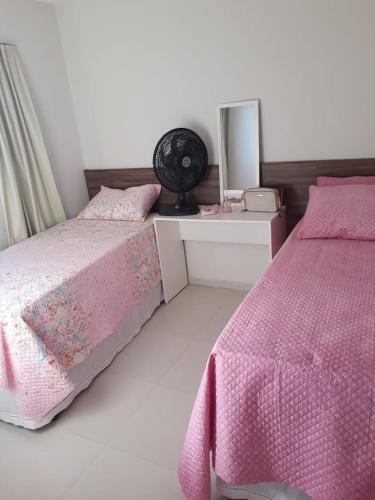 a bedroom with two beds and a desk with a fan at Apartamento Condomínio Sonhos da Serra - Bananeiras in Bananeiras