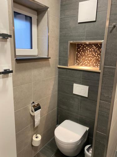 a small bathroom with a toilet and a window at Apartment 1 in Zella-Mehlis