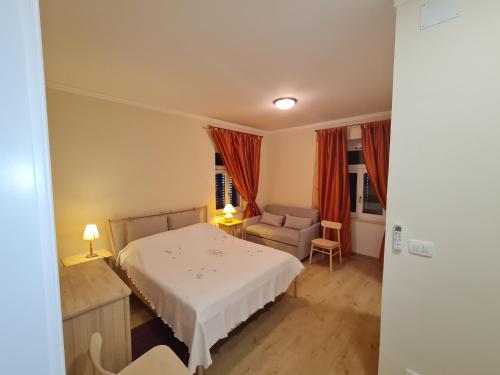 sypialnia z białym łóżkiem i krzesłem w obiekcie Villa Jure - Apartment Vlasta w mieście Lovran
