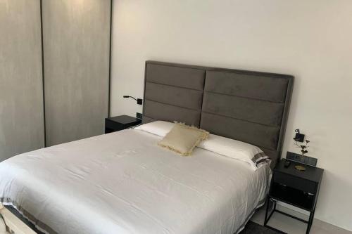 ein Schlafzimmer mit einem weißen Bett mit einem großen Kopfteil in der Unterkunft Amazing house close to the beach in Port d'Alcúdia