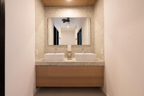 Baño con 2 lavabos y espejo en Mayan Monkey Tulum en Tulum