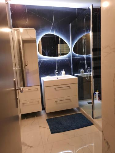 une salle de bain avec un lavabo et un miroir dans l'établissement Mon petit Paradis, Cassis centre Apt 90 m2, 200 m Mer, terr plein sud, clim park privé, à Cassis