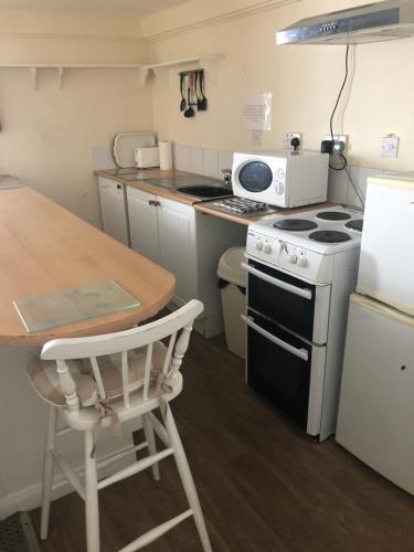a small kitchen with a stove and a table at The Mayfair Hotel in Great Yarmouth
