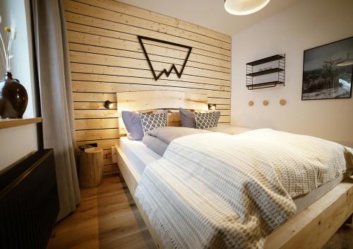 a bedroom with a bed and a wooden wall at Chalet Hans in Kurort Oberwiesenthal
