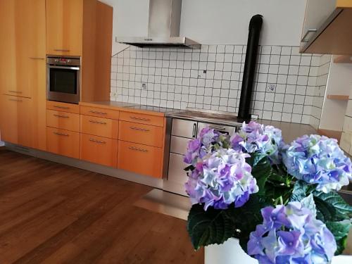 a kitchen with a vase of purple flowers at Ansitz Grustdorf in Appiano sulla Strada del Vino