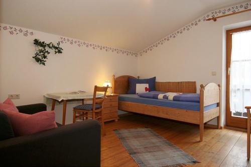 a bedroom with a bed and a table and a desk at Ferienwohnung Lauer in Schönau am Königssee