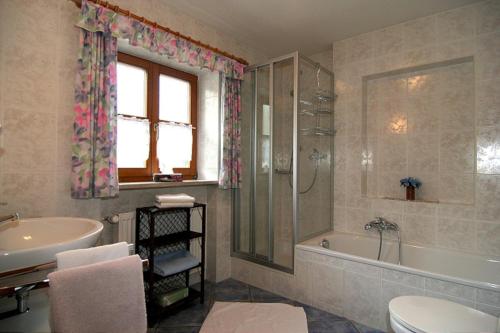 a bathroom with a tub and a sink and a toilet at Ferienwohnung Lauer in Schönau am Königssee