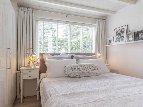 a white bedroom with a bed and a window at Vakantiewoningen Prelude & Etude in Wieringerwaard