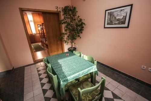 a dining room with a table and chairs and a plant at Hostel Terasa in Novi Sad