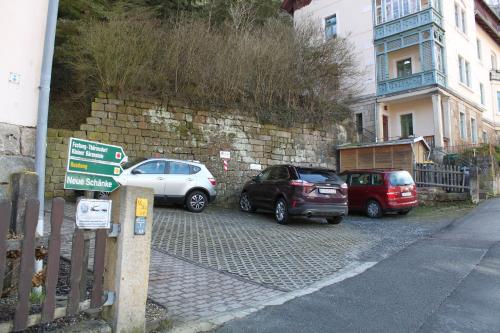drei Autos auf einem Parkplatz neben einer Mauer geparkt in der Unterkunft Ferienwohnungen endlich urlaub in Königstein an der Elbe