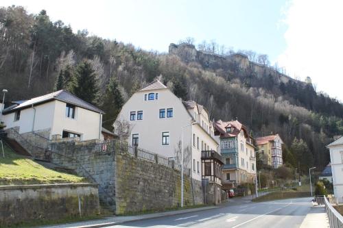 a group of buildings on a street next to a mountain at Ferienwohnungen endlich urlaub in Königstein an der Elbe