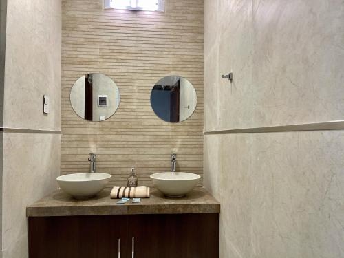 a bathroom with two sinks and two mirrors at City Center 3-rooms apartment Downtown Sucre in Sucre