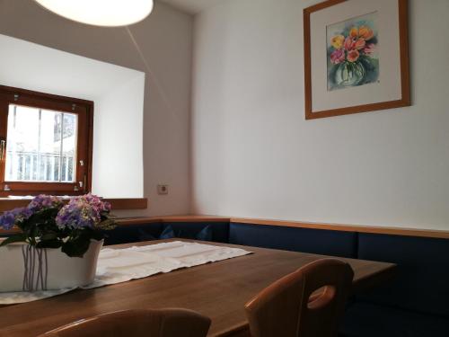 a dining room with a table and a vase of flowers at Ansitz Grustdorf in Appiano sulla Strada del Vino
