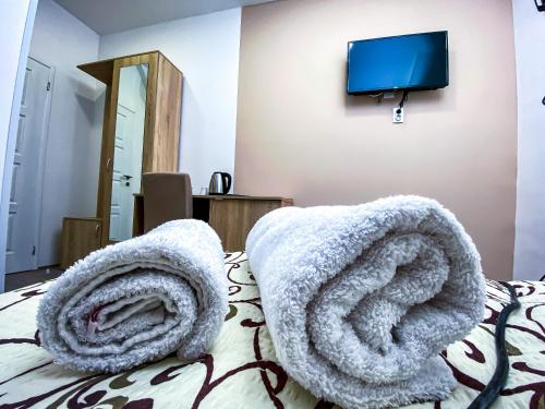 a bedroom with a bed with towels on it at Kiko apartmani in Zrenjanin