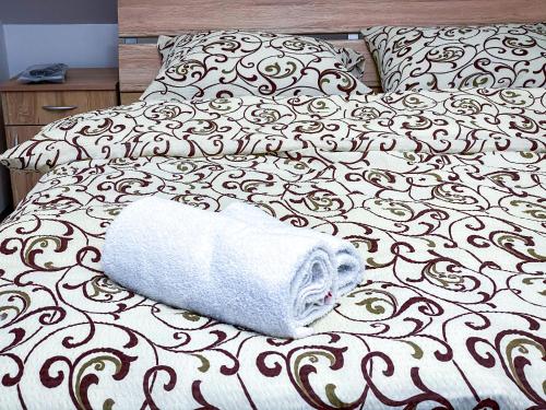a white towel laying on top of a bed at Kiko apartmani in Zrenjanin