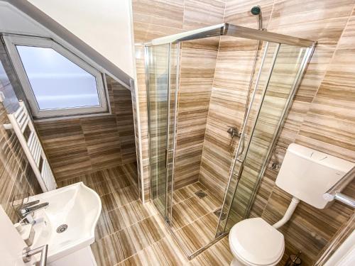 a bathroom with a shower and a toilet at Kiko apartmani in Zrenjanin