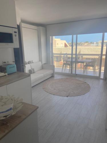 a living room with a white couch and a table at A 2 passi dal mare! in Es Pujols