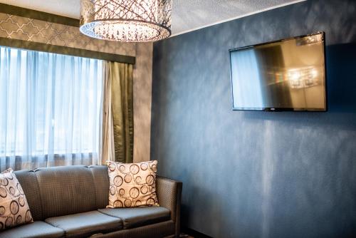a living room with a couch and a tv on a wall at Gateway Inn and Suites in Salida