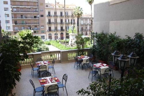 a patio with tables and chairs in a building at Hotel Joli in Palermo