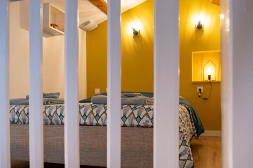 a bedroom with two beds with yellow walls at Le Duplex à Mimine in Le Pin-en-Mauges