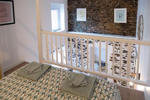 una escalera con una barandilla blanca y una pared de piedra en Le Duplex à Mimine en Le Pin-en-Mauges