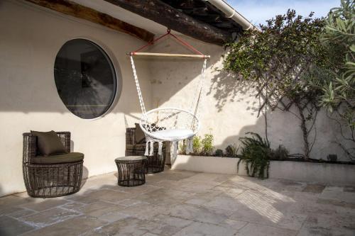 a patio with a chair and a swing at La Comédie de Pézenas - Appartements in Pézenas