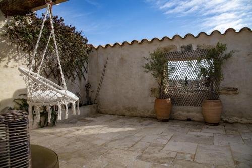 a patio with a chair hanging from a wall at La Comédie de Pézenas - Appartements in Pézenas