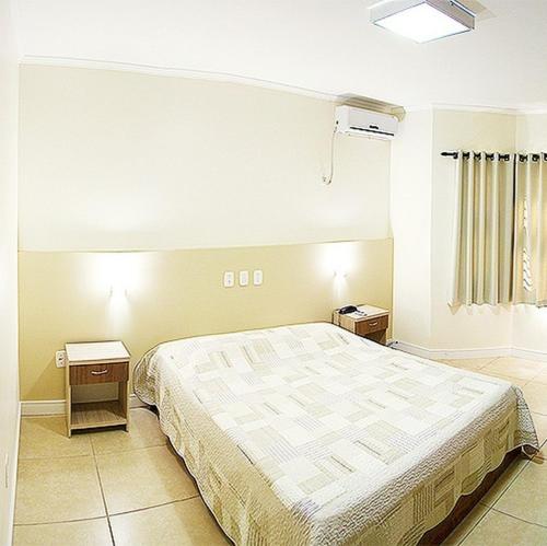 1 dormitorio con 1 cama grande y 2 mesitas de noche en Senior Parque Hotel, en Santa Rosa
