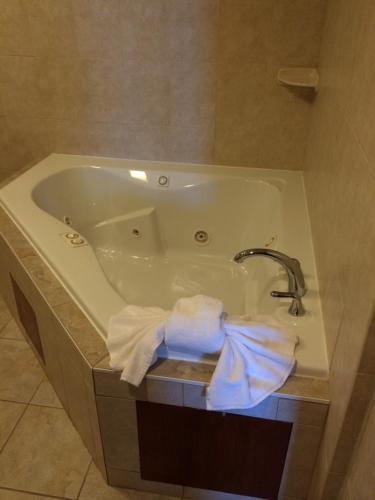 a bath tub with a faucet and towels in a bathroom at Pacer Inn & Suites Motel in Delaware