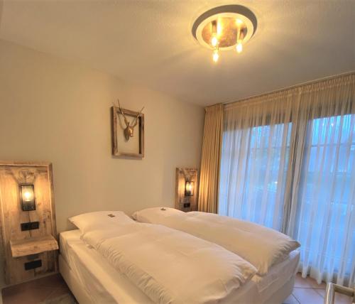 1 dormitorio con cama y ventana grande en Luxus Ferienwohnung Ausspann, en Hahnenklee-Bockswiese