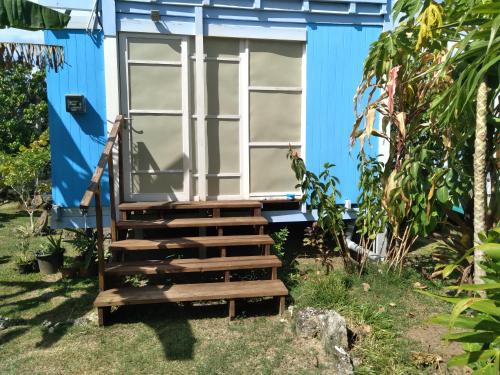 a blue house with stairs leading up to it at Bungalow les pieds ds l eau, La Maison Bleue in Moorea