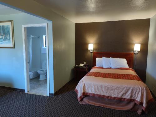 a hotel room with a bed and a bathroom at Economy Inn Richmond in Richmond