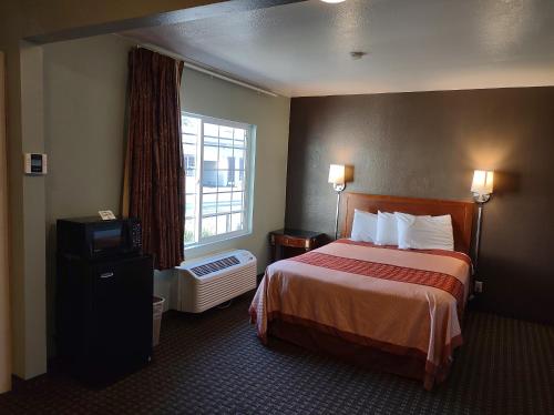 a hotel room with a bed and a window at Economy Inn Richmond in Richmond