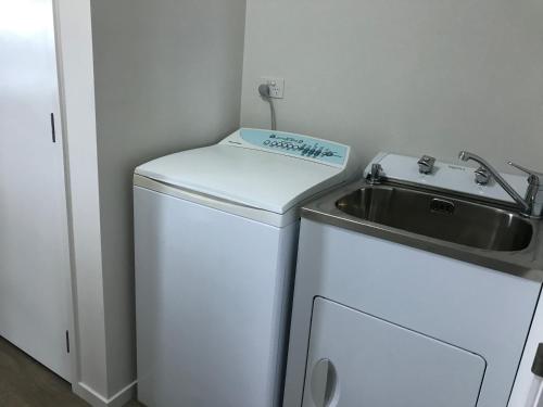 a small kitchen with a sink and a small refrigerator at Sunset Point Kerikeri in Kerikeri