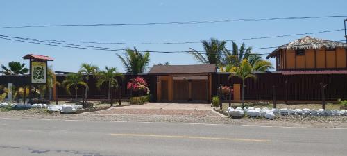 ein Haus an der Seite einer Straße mit einem Zaun in der Unterkunft Guille Bungalows in Canoas De Punta Sal