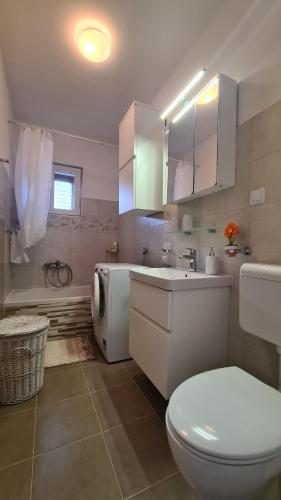 a bathroom with a toilet and a sink and a tub at Apartment Antonia in Stari Grad