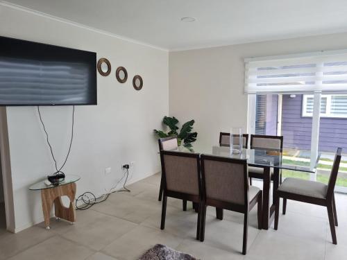 a dining room with a table and a tv at Cabañas Alto Volcanes in Puerto Montt