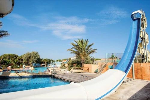 - un toboggan dans un complexe avec piscine dans l'établissement Mobil Home camping Mar Estang bord de plage, à Canet