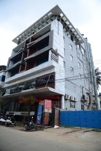 a building with a motorcycle parked in front of it at Miles Inn Hotel in Hassan