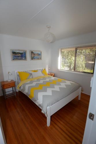 a bedroom with a bed with yellow and white sheets at Sea-Esta @ Inverloch in Inverloch