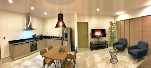 cocina y sala de estar con mesa y sillas en Encantador Departamento en Residencial con Alberca, en Cancún