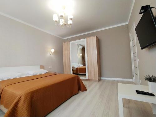 1 dormitorio con 1 cama y TV de pantalla plana en квартира в Жилом комплексе Левитана,массив Радужный en Odesa