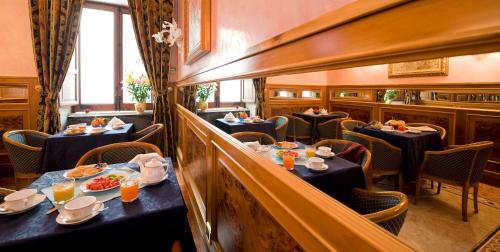 a restaurant with tables and chairs with food on them at Hotel Joli in Palermo
