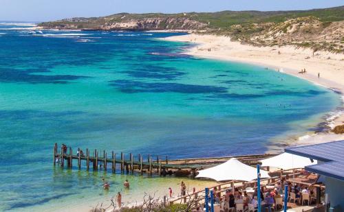 a view of a beach with a pier and people in the water at Stylish Colourfull Getaway in Margaret River Town